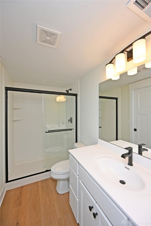 bathroom featuring hardwood / wood-style floors, an enclosed shower, vanity, and toilet