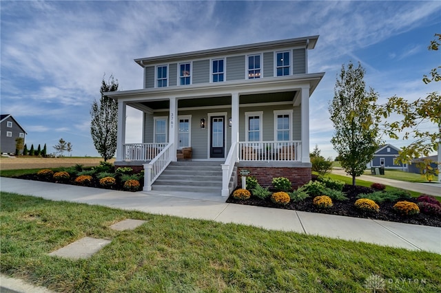 view of front facade featuring a front yard and covered porch