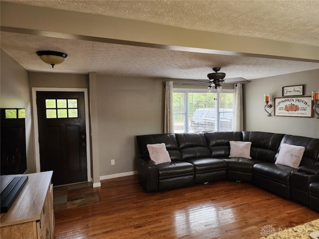 living room with a textured ceiling, a ceiling fan, baseboards, and hardwood / wood-style floors