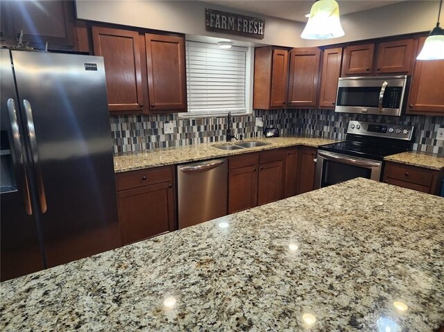 kitchen with a sink, decorative backsplash, light stone countertops, and stainless steel appliances