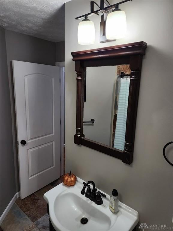 bathroom featuring a textured ceiling and a sink