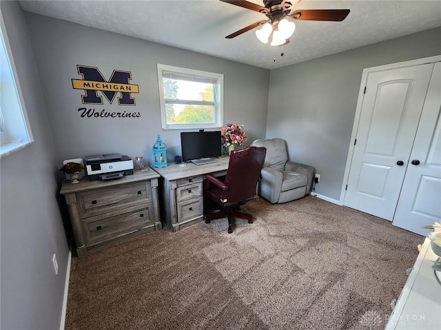 office featuring baseboards, carpet, ceiling fan, and a textured ceiling