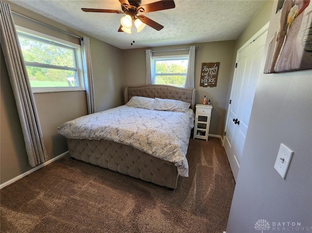 carpeted bedroom featuring a textured ceiling, baseboards, and a ceiling fan