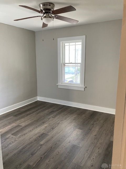 spare room featuring dark hardwood / wood-style flooring and ceiling fan