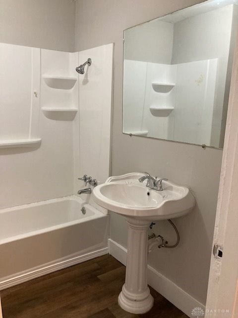 bathroom with hardwood / wood-style floors and shower / washtub combination