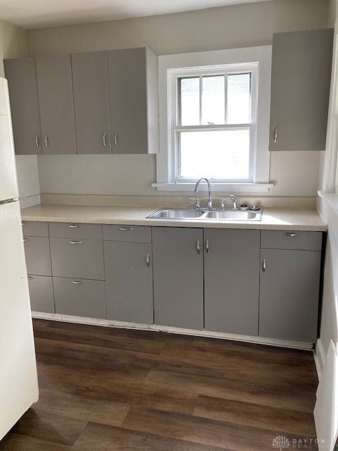 kitchen with white refrigerator, sink, dark hardwood / wood-style flooring, and gray cabinets