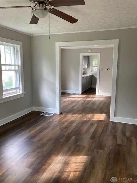 spare room featuring plenty of natural light, dark hardwood / wood-style flooring, and ceiling fan