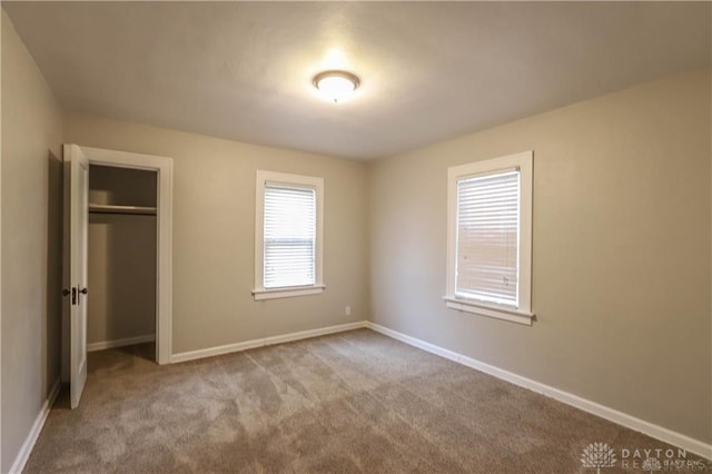 unfurnished bedroom featuring a closet and light carpet