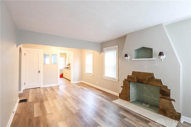 living room with light wood-type flooring and a large fireplace