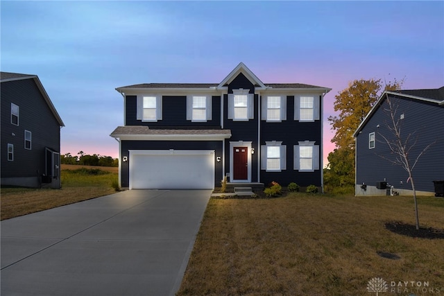 view of front of home with a garage and a lawn