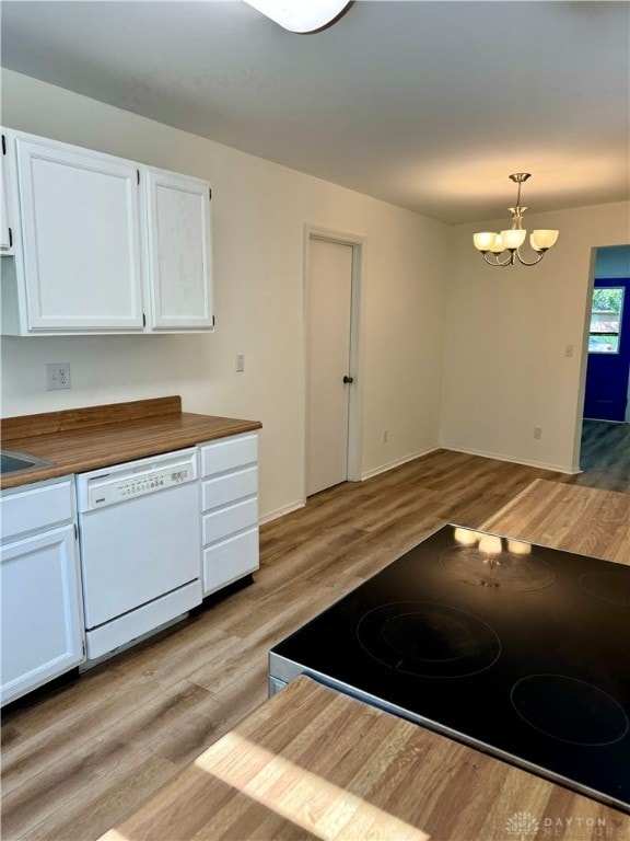 kitchen with wood counters, hanging light fixtures, dishwasher, and white cabinets