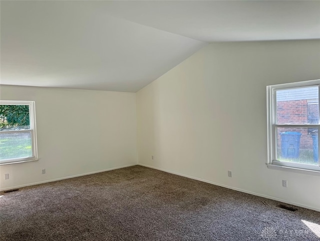 carpeted empty room with lofted ceiling