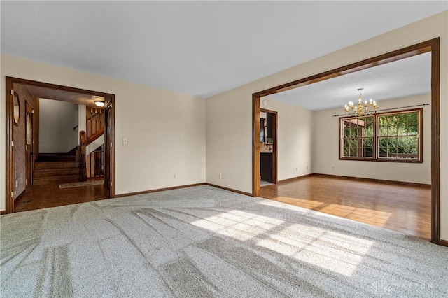 empty room featuring a notable chandelier and hardwood / wood-style floors