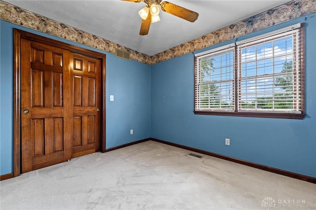 carpeted empty room featuring ceiling fan