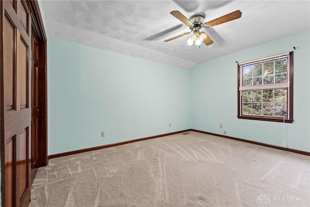 unfurnished room featuring ceiling fan, vaulted ceiling, and light colored carpet