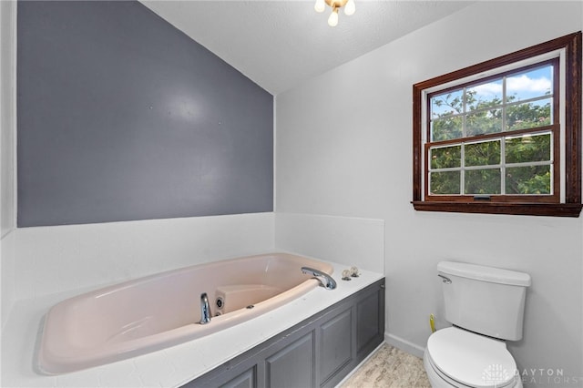 bathroom featuring a textured ceiling, lofted ceiling, toilet, and a washtub