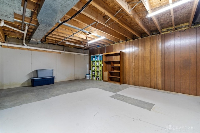 basement featuring wood walls