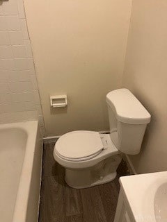 bathroom featuring a bath, vanity, toilet, and wood-type flooring