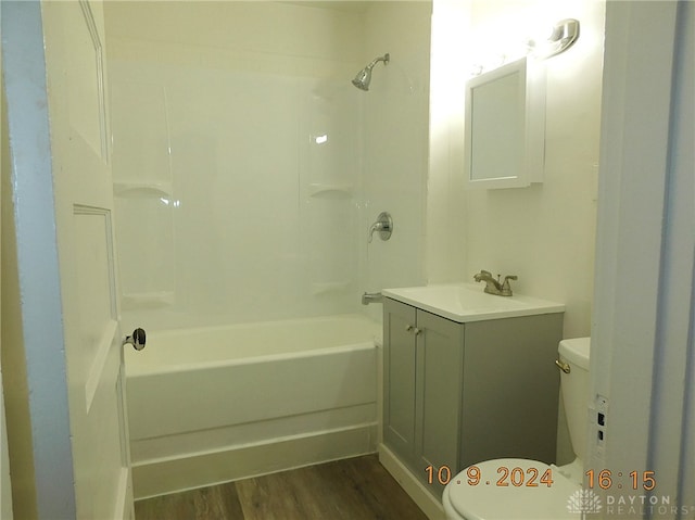 full bathroom featuring washtub / shower combination, vanity, wood-type flooring, and toilet