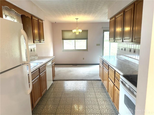 kitchen with decorative light fixtures, a textured ceiling, white appliances, decorative backsplash, and a chandelier