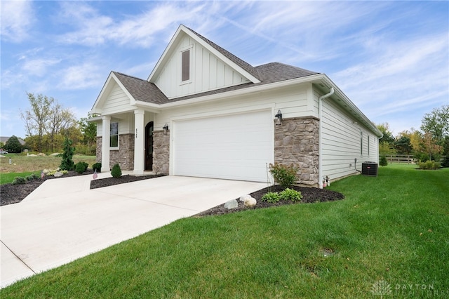 view of front of property with central air condition unit, a front yard, and a garage