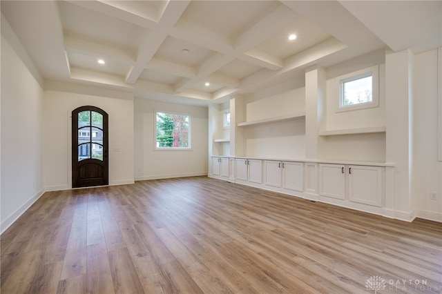 interior space featuring beamed ceiling, coffered ceiling, and light hardwood / wood-style floors