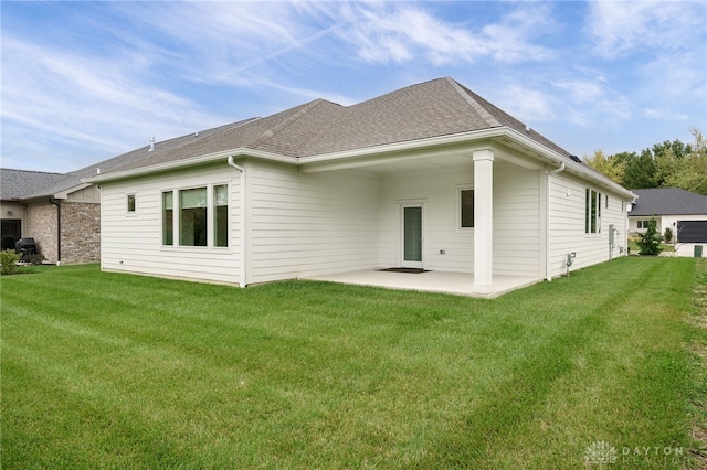 rear view of property featuring a lawn and a patio