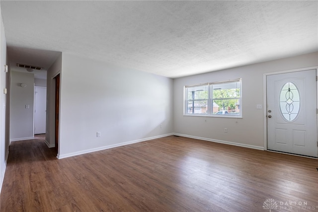 foyer featuring a textured ceiling and dark hardwood / wood-style flooring