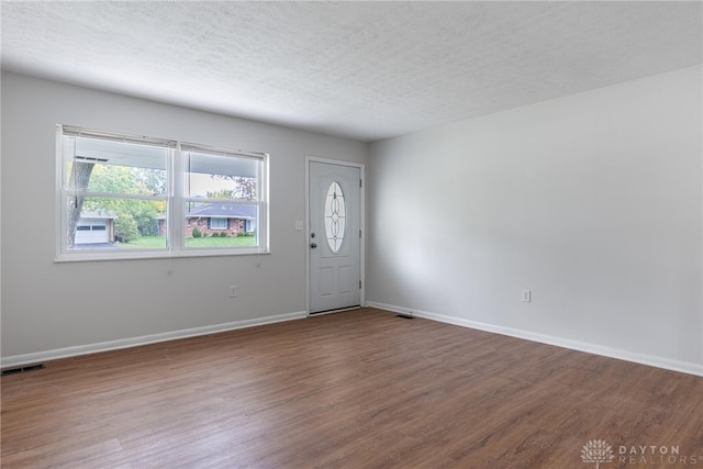 foyer entrance with hardwood / wood-style floors and a textured ceiling