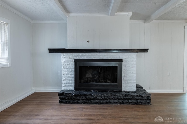 details with hardwood / wood-style floors, a fireplace, a textured ceiling, ornamental molding, and beamed ceiling