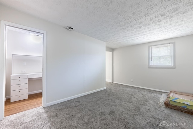 unfurnished room with carpet floors and a textured ceiling