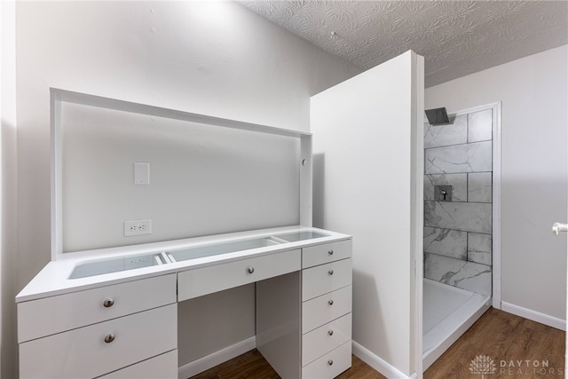 bathroom with a shower, a textured ceiling, and hardwood / wood-style flooring