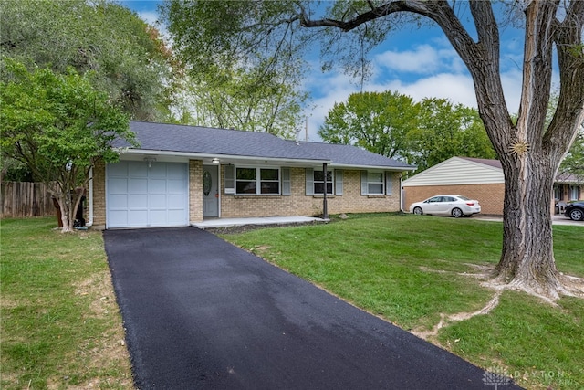 ranch-style house featuring a front lawn and a garage