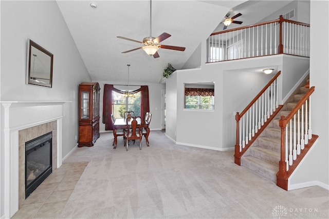 interior space featuring ceiling fan, a fireplace, and high vaulted ceiling