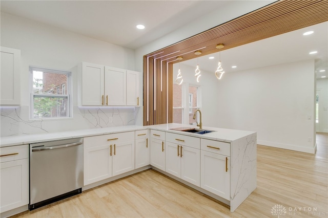 kitchen with backsplash, dishwasher, pendant lighting, sink, and white cabinets