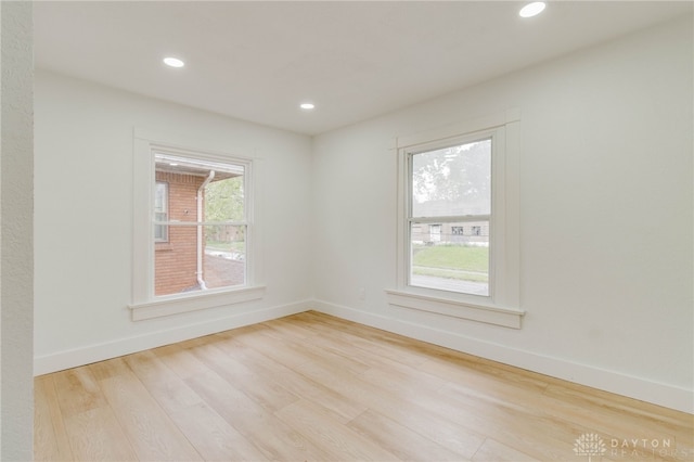 empty room featuring plenty of natural light and light hardwood / wood-style flooring