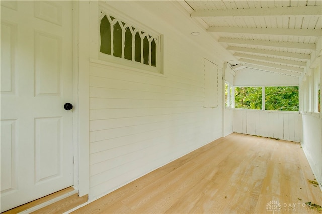 exterior space featuring wood walls, wooden ceiling, and lofted ceiling with beams