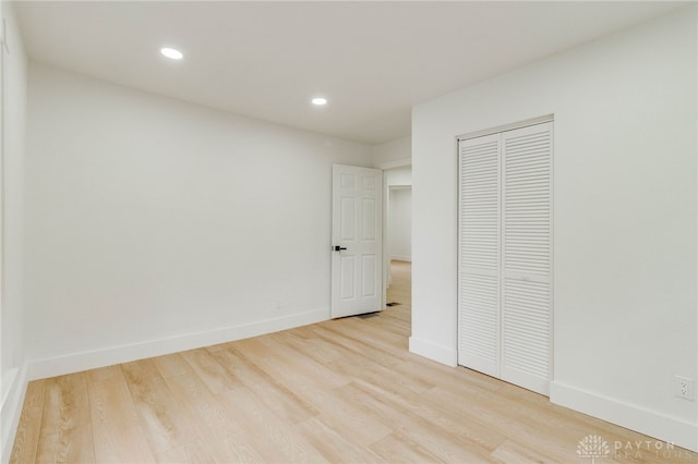 unfurnished bedroom featuring a closet and light wood-type flooring