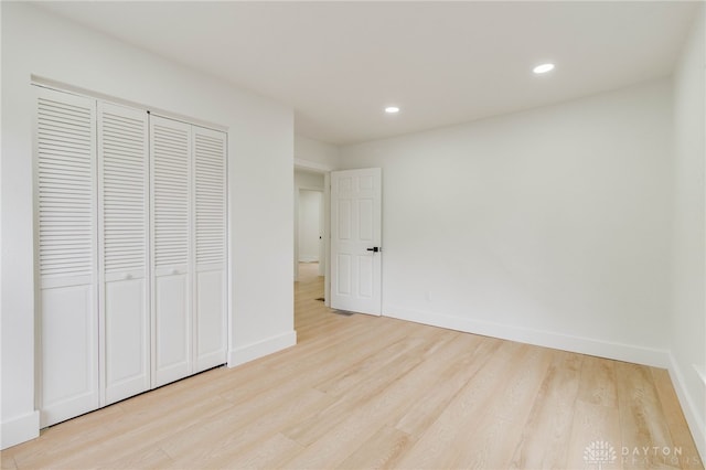 unfurnished bedroom with a closet and light hardwood / wood-style flooring