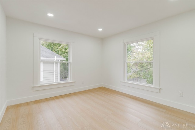 empty room featuring a healthy amount of sunlight and light hardwood / wood-style flooring