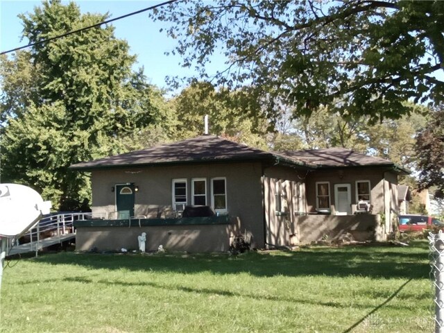 rear view of house featuring a lawn