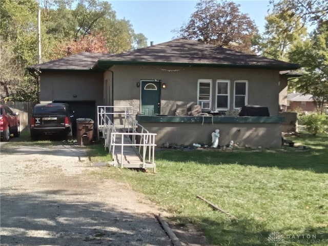 view of front of property with driveway, a garage, a front yard, and stucco siding