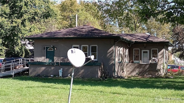 view of side of property with a yard and stucco siding