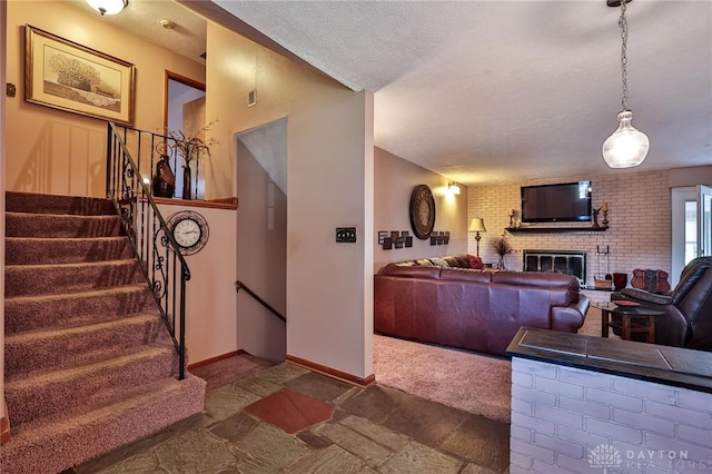 living room featuring a brick fireplace and a textured ceiling