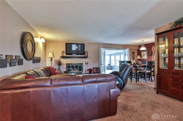 living room featuring a fireplace, carpet, and a textured ceiling