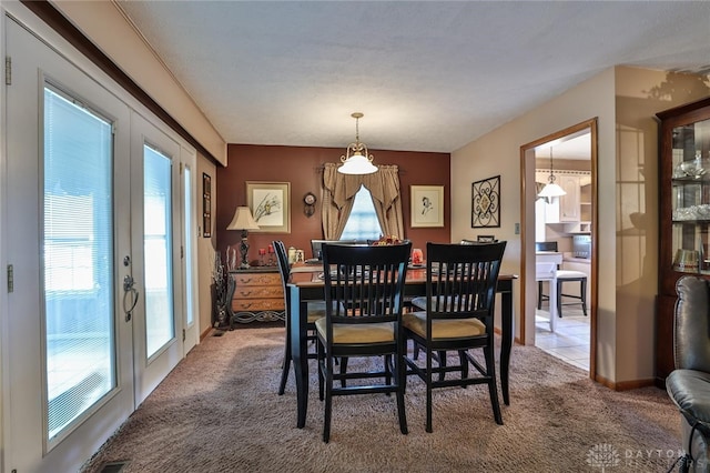 dining space with french doors and carpet