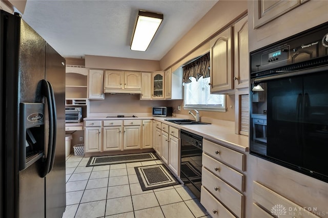 kitchen featuring sink, light tile patterned floors, and black appliances