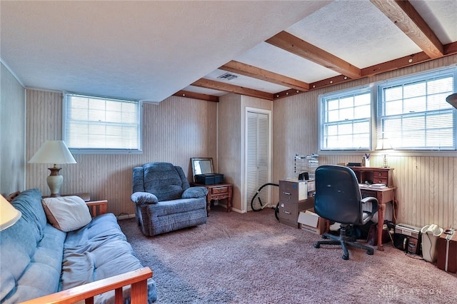 carpeted home office featuring beamed ceiling, a textured ceiling, and a wealth of natural light