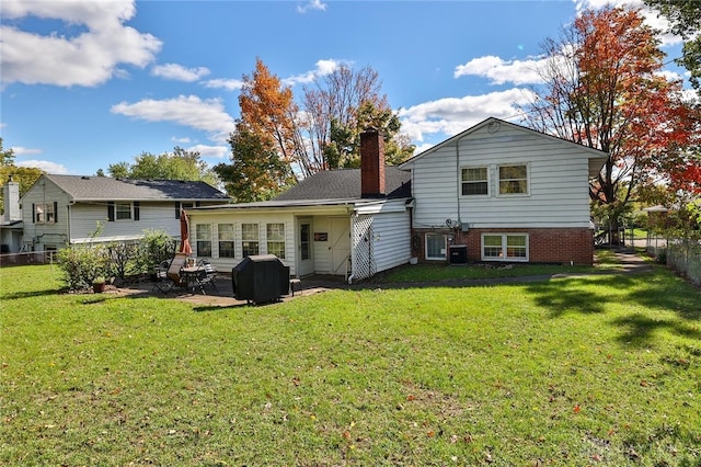 back of property with cooling unit, a lawn, and a patio area