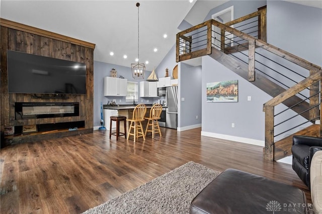 living room featuring dark hardwood / wood-style flooring, an inviting chandelier, and lofted ceiling